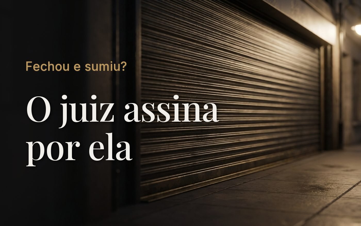 Porta de aço fechada de um comércio ao anoitecer, calçada vazia e luz de poste incidindo pela lateral direita