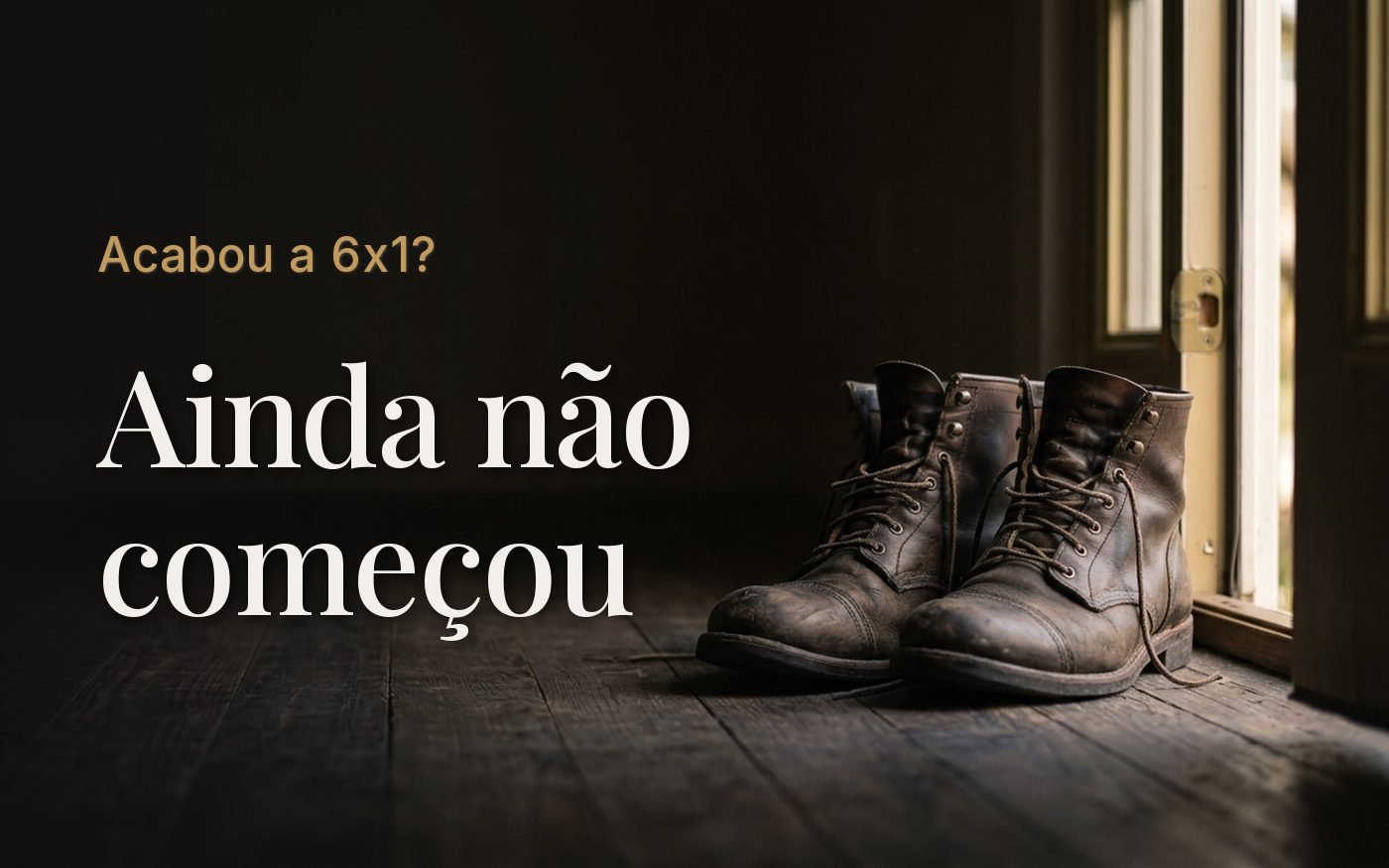 Par de botas de trabalho gastas lado a lado no chão de madeira, junto a uma porta entreaberta com a luz da manhã